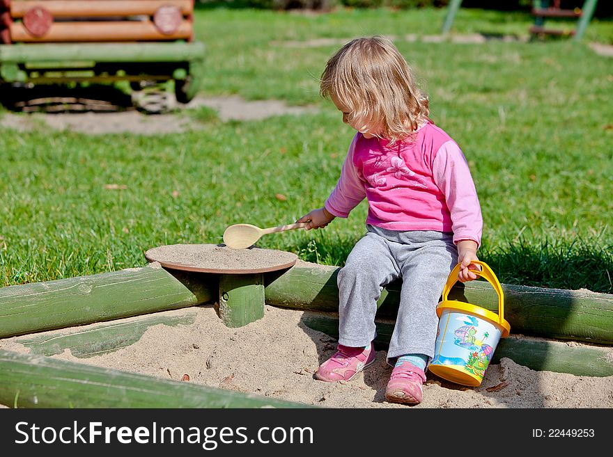 Cute toddler girl playing with sand toy on a sandbox. Cute toddler girl playing with sand toy on a sandbox