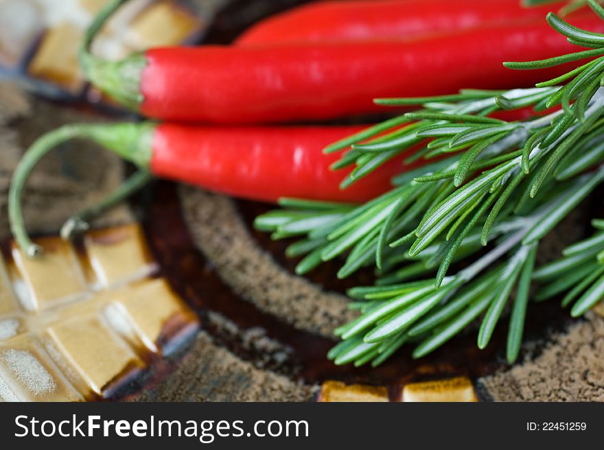 Rosemary and red chili pepper on a ceramic plate