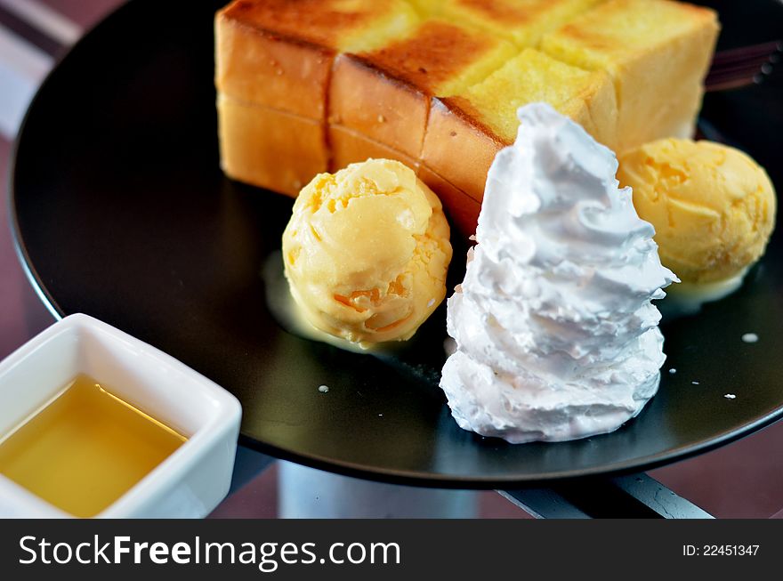 Toast and whipping cream with vanilla ice cream served with honey sauce. Toast and whipping cream with vanilla ice cream served with honey sauce