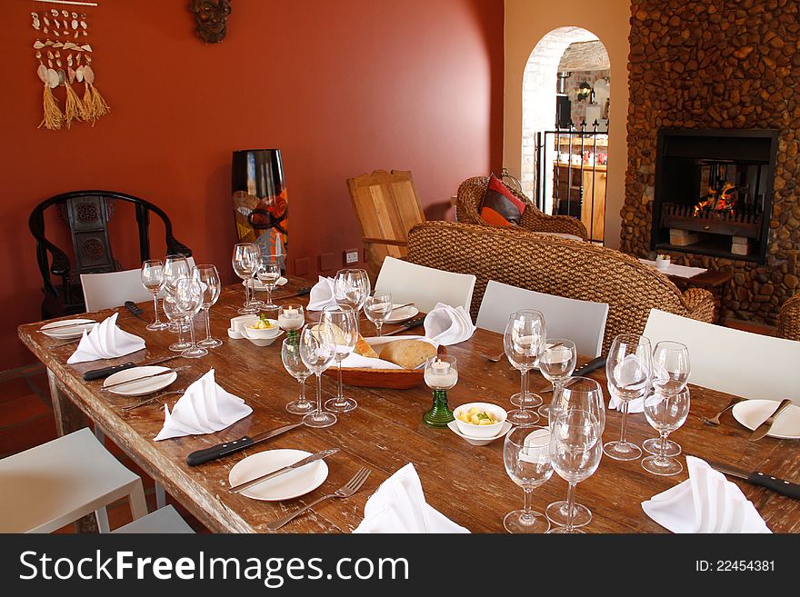 Interior of a restaurant with set wooden table and a fireplace. Interior of a restaurant with set wooden table and a fireplace