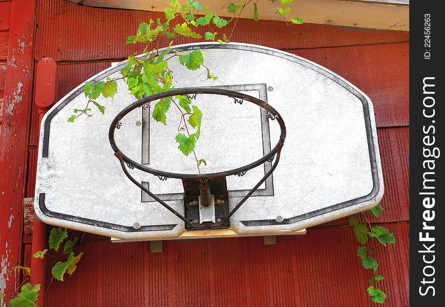 Old and unused basketball hoop with no net, attached to the side of an old red building. Old and unused basketball hoop with no net, attached to the side of an old red building.
