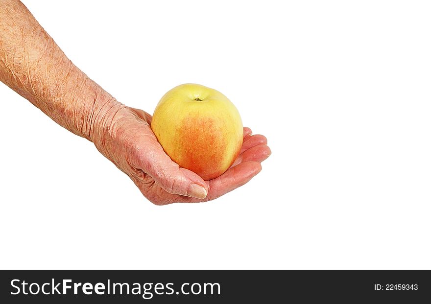 An elderly woman's hand with an apple on a white background. An elderly woman's hand with an apple on a white background