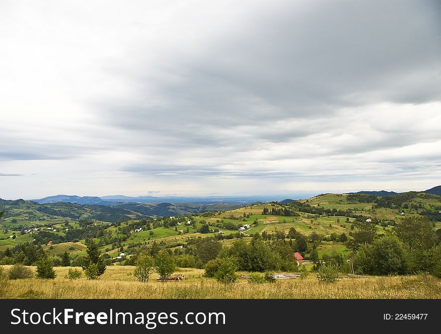 Landscape picture of a mountain village in Transylvania with dramatic sky and clouds. Landscape picture of a mountain village in Transylvania with dramatic sky and clouds.