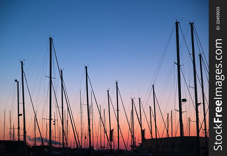 Masts of sail boats in sunset