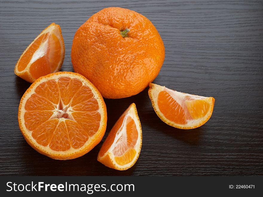 Tangerines on the background of dark wood