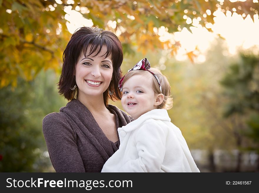 Attractive Mother and Daughter Portrait Outside at the Park.