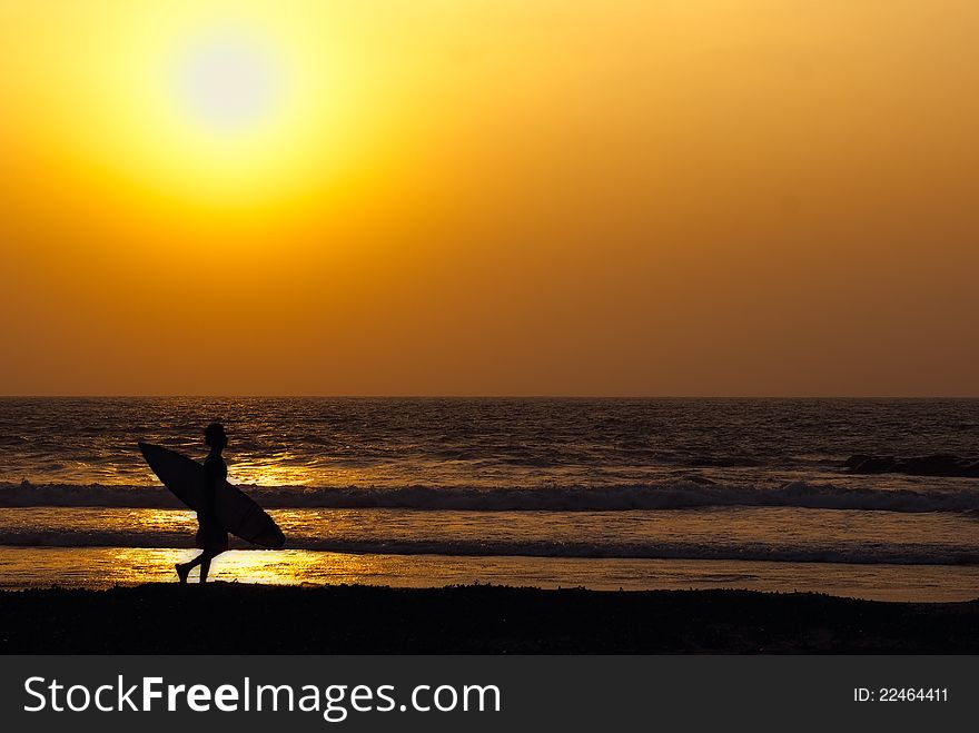 Silhouette Of A Man Walking Along The Coast With S