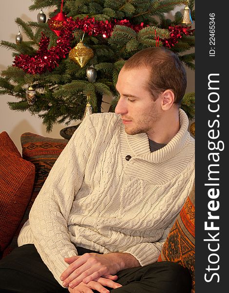 White young man celebrating holiday , christmas tree in background. White young man celebrating holiday , christmas tree in background