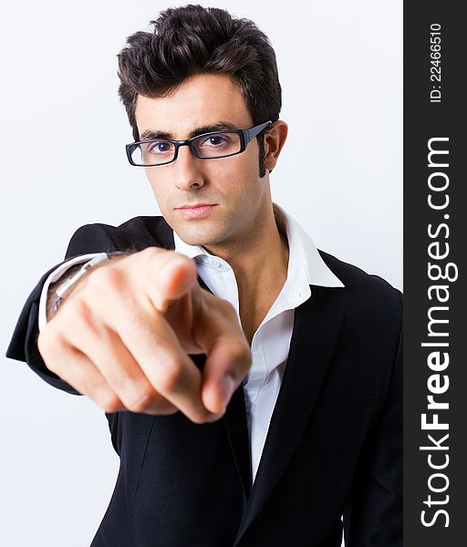 Attractive young businessman whit his glasses pointing at the camera. Attractive young businessman whit his glasses pointing at the camera