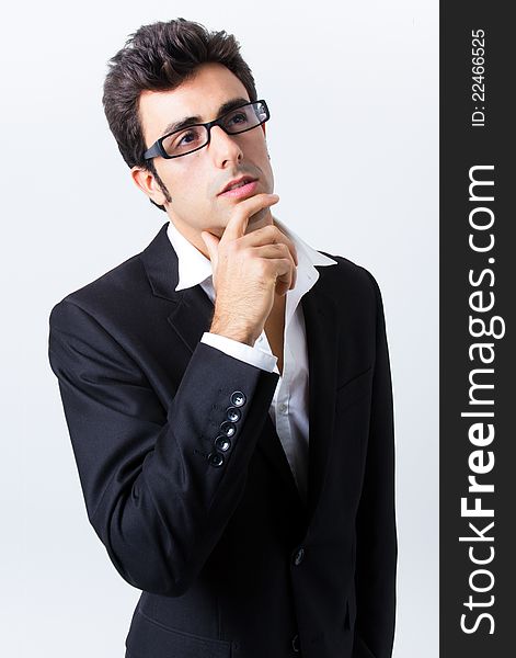 Attractive young businessman with his glasses, thinking. Attractive young businessman with his glasses, thinking