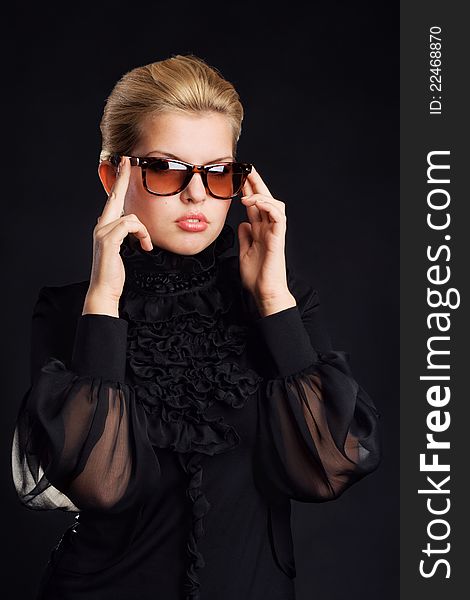 Gorgeous woman in sunglasses against black background