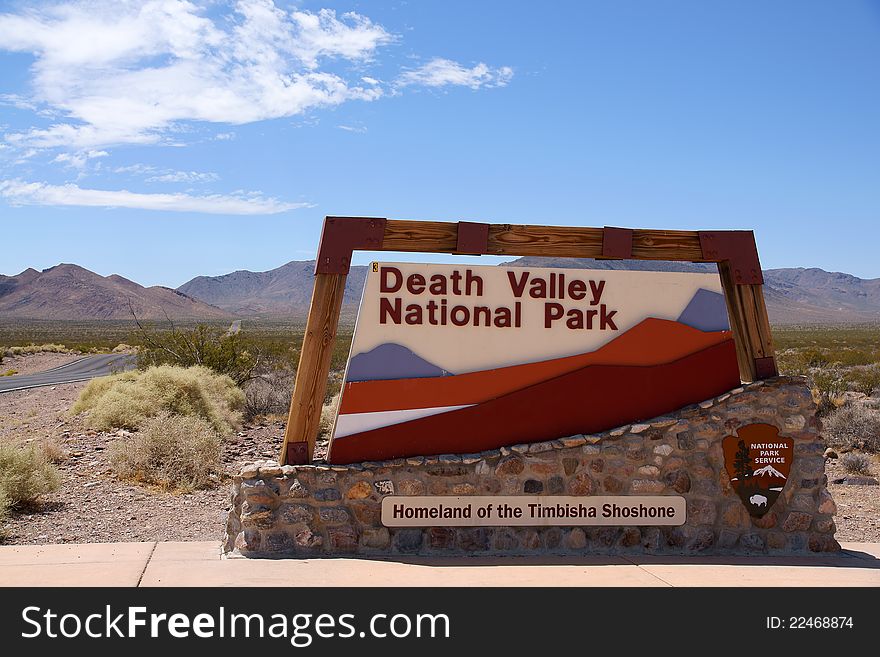 Death Valley National Park sign with desert and mountains in background, California and Nevada, U.S.A. Death Valley National Park sign with desert and mountains in background, California and Nevada, U.S.A.