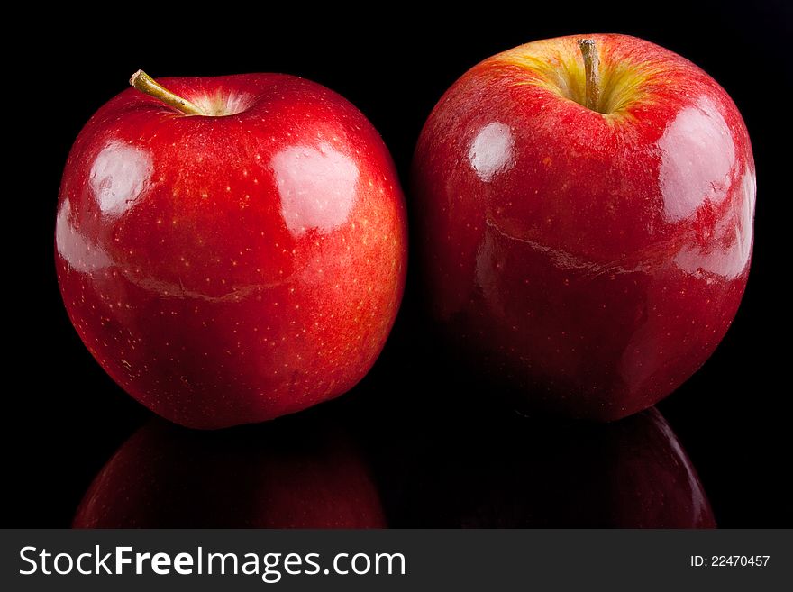 Two red glossy apples on black background. Two red glossy apples on black background