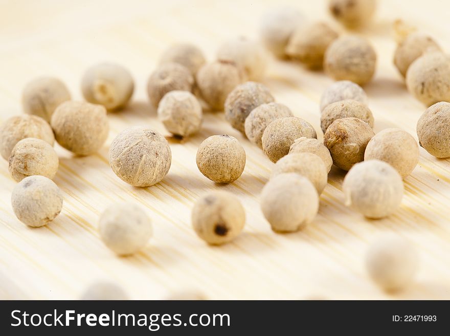 A collection of white pepper corns on wood