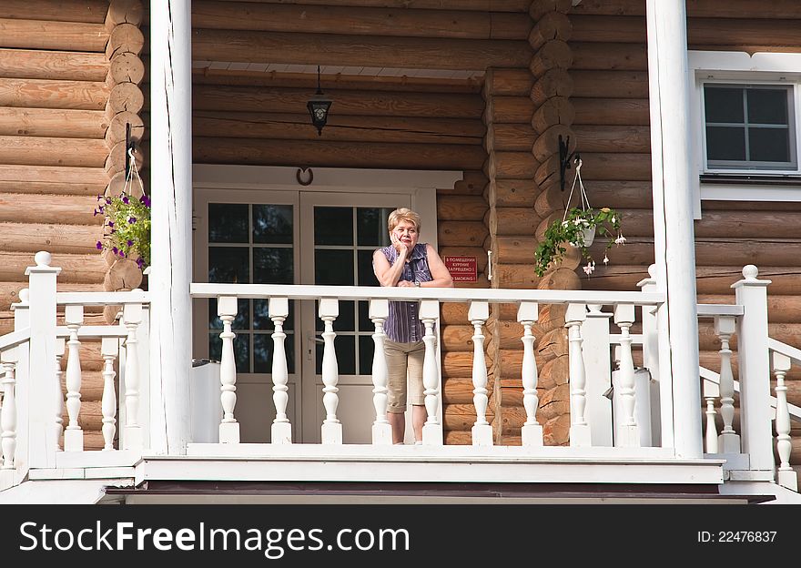 The woman on the balcony of a log cabin