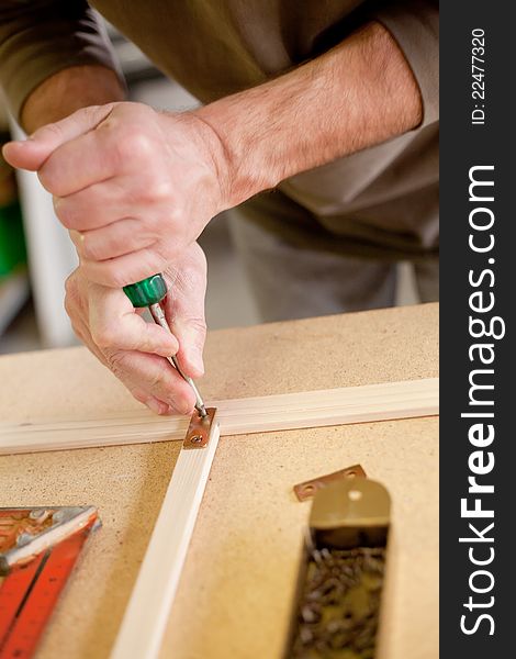 Marking a hole in the wood over a wood workbench. Marking a hole in the wood over a wood workbench