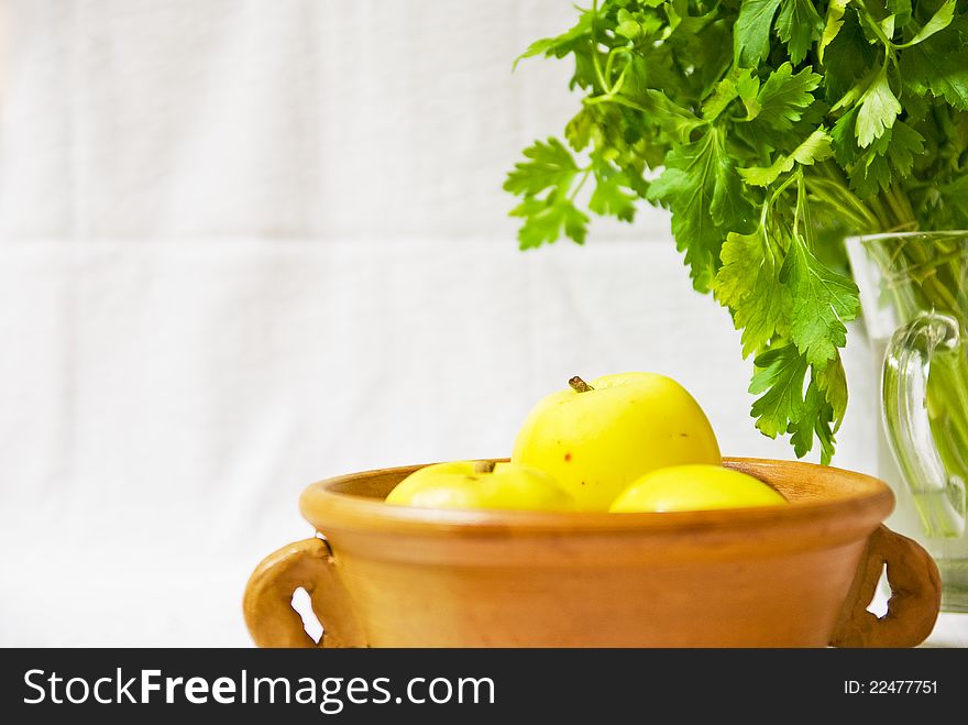 Retro still life with yellow apples in a clay bowl and fresh parsley, with space. Retro still life with yellow apples in a clay bowl and fresh parsley, with space.