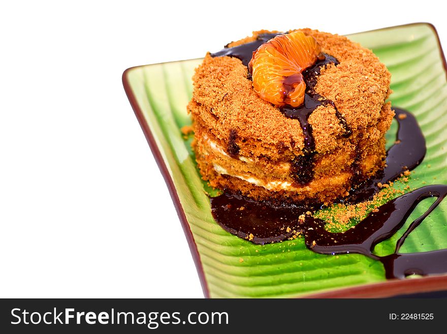 Close-up on a slice of honey cake with chocolate on white background