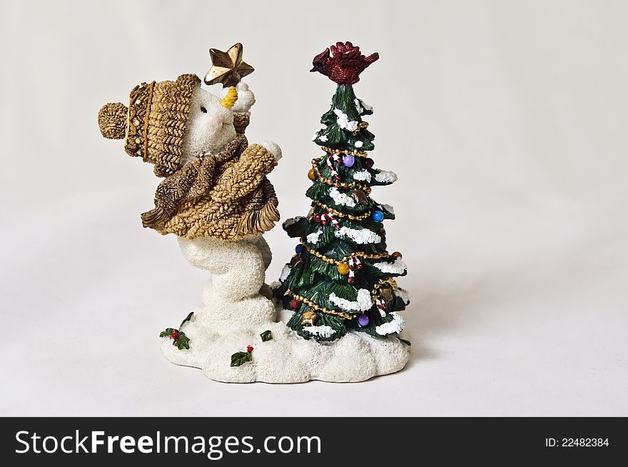 Snowman with gold star decorating christmas tree