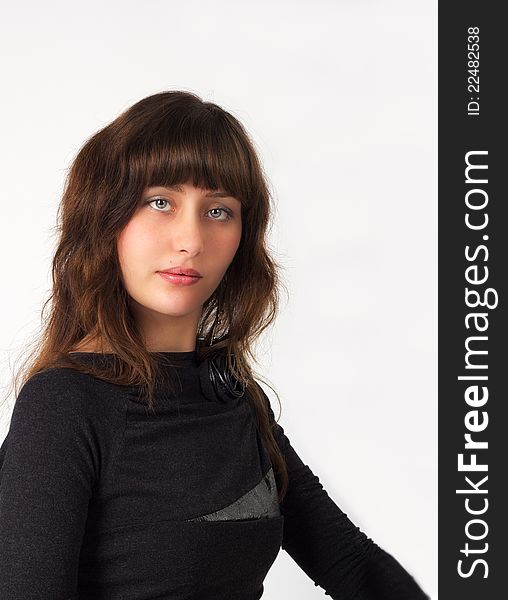 Portrait of pretty young girl in black dress in studio