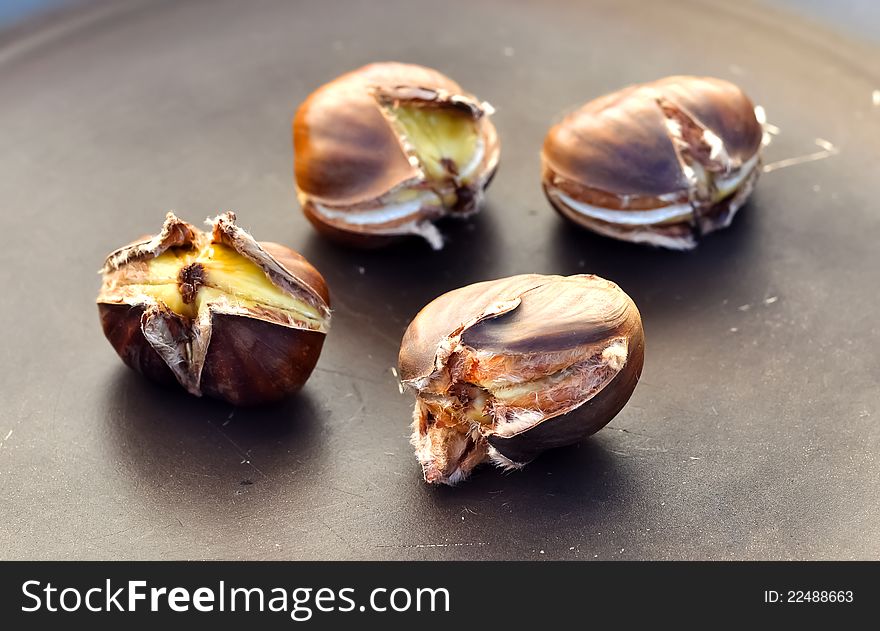 Four chestnuts in a pan while being baked. Four chestnuts in a pan while being baked
