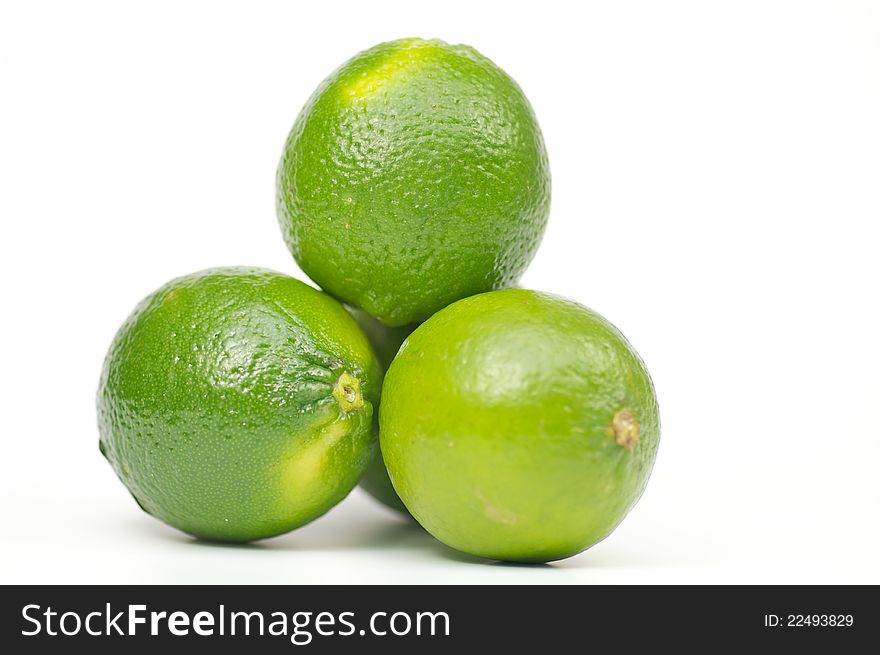 Three green limes on white background