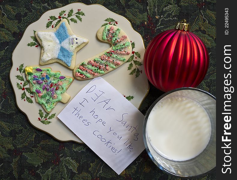 A child leaves a note for Santa Claus with milk and sugar cookies. A child leaves a note for Santa Claus with milk and sugar cookies.