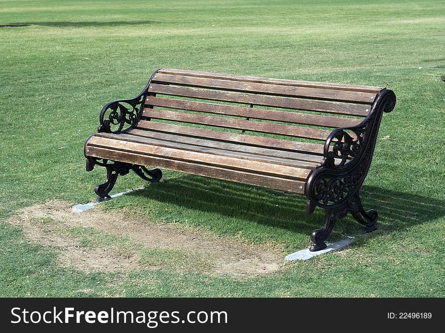 A brown garden bench on grass