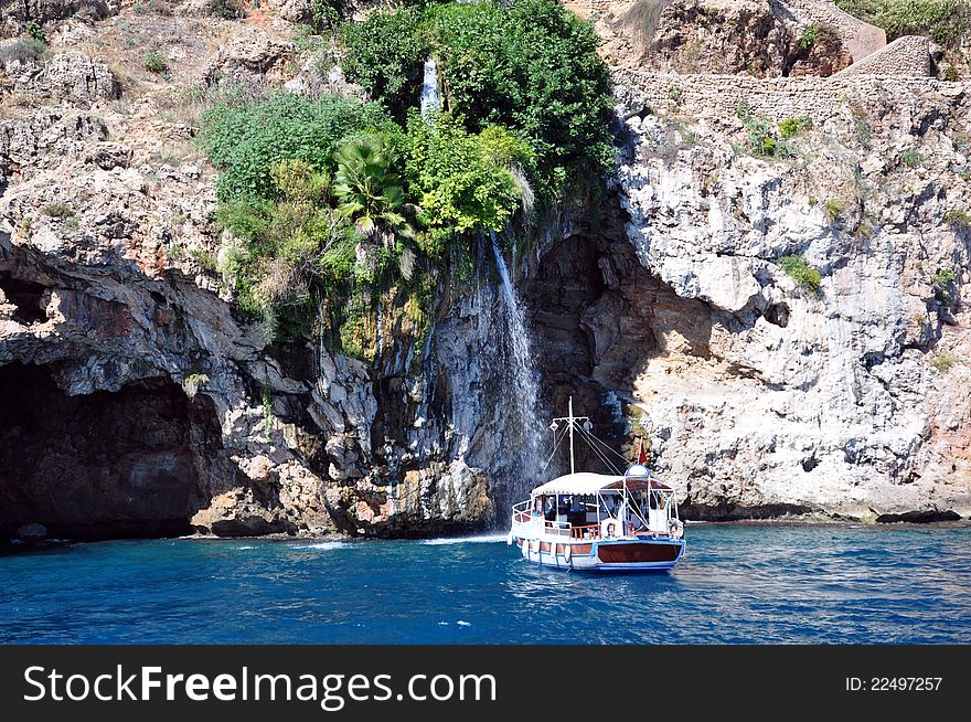 A local cruise boat visiting a waterfall at antalya in turkey. A local cruise boat visiting a waterfall at antalya in turkey