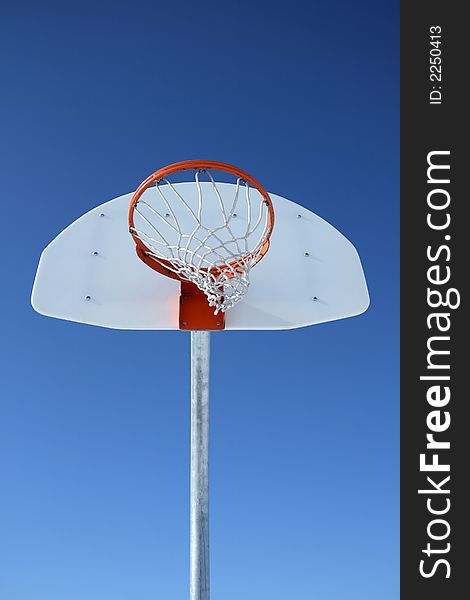 Basketball backboard, hoop and net against the blue sky. Basketball backboard, hoop and net against the blue sky.