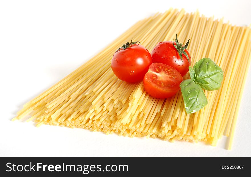 Close up of spaghetti, tomatoes and basil isolated on a white background. Close up of spaghetti, tomatoes and basil isolated on a white background