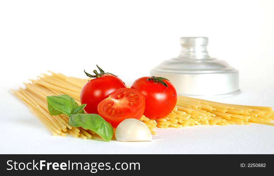 Close up of spaghetti, tomatoes,garlic and basil isolated on a white background. Close up of spaghetti, tomatoes,garlic and basil isolated on a white background
