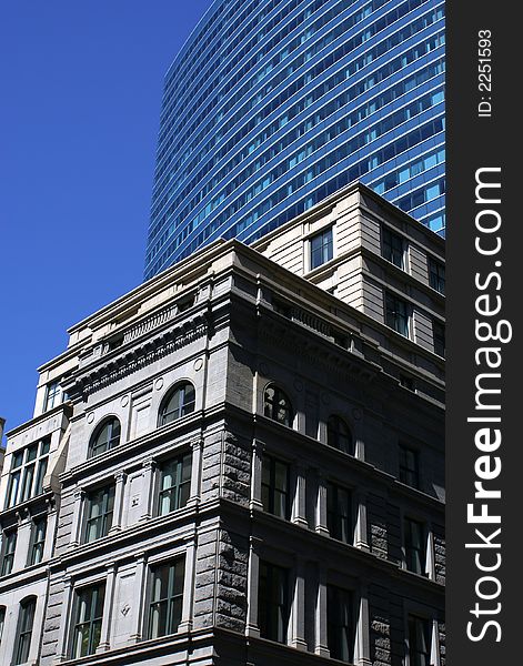 Old stately building in downtown boston against a deep blue sky with modern building in background