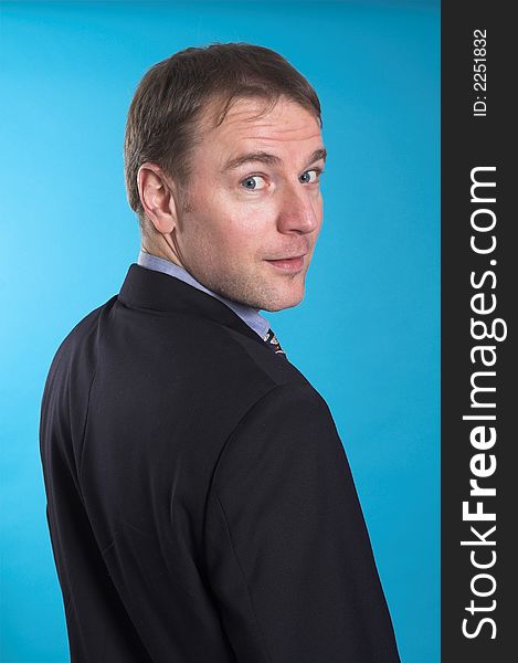 Man in business suit standing over blue background. Man in business suit standing over blue background