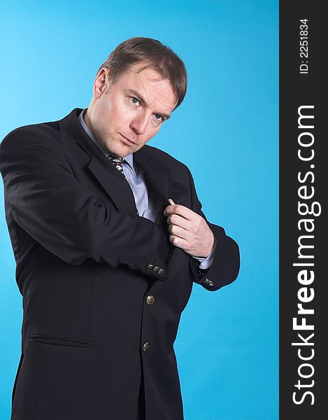 Man in business suit standing over blue background searching his pocket. Man in business suit standing over blue background searching his pocket