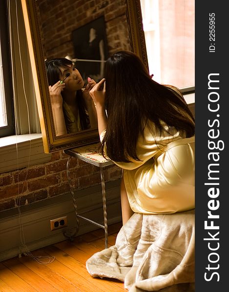 Reflection of girl applying eye makeup. Reflection of girl applying eye makeup