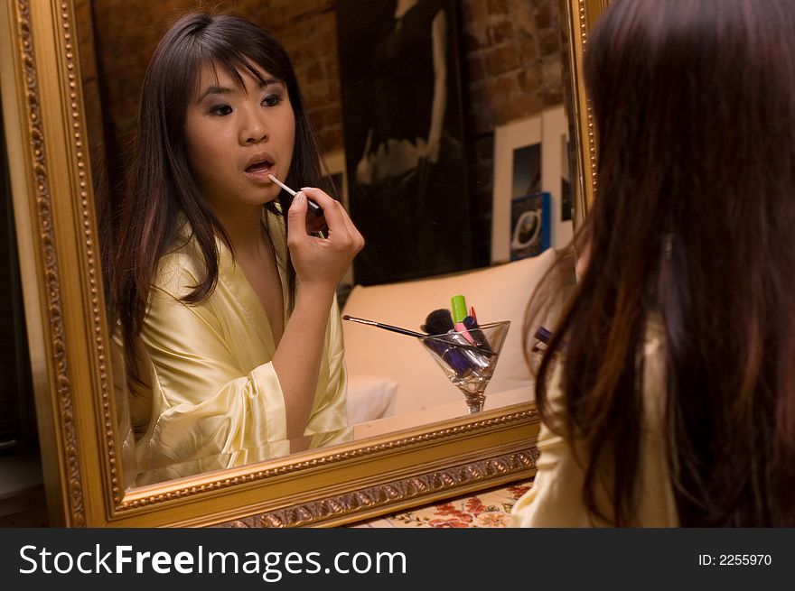 Reflection of girl applying lipstick. Reflection of girl applying lipstick
