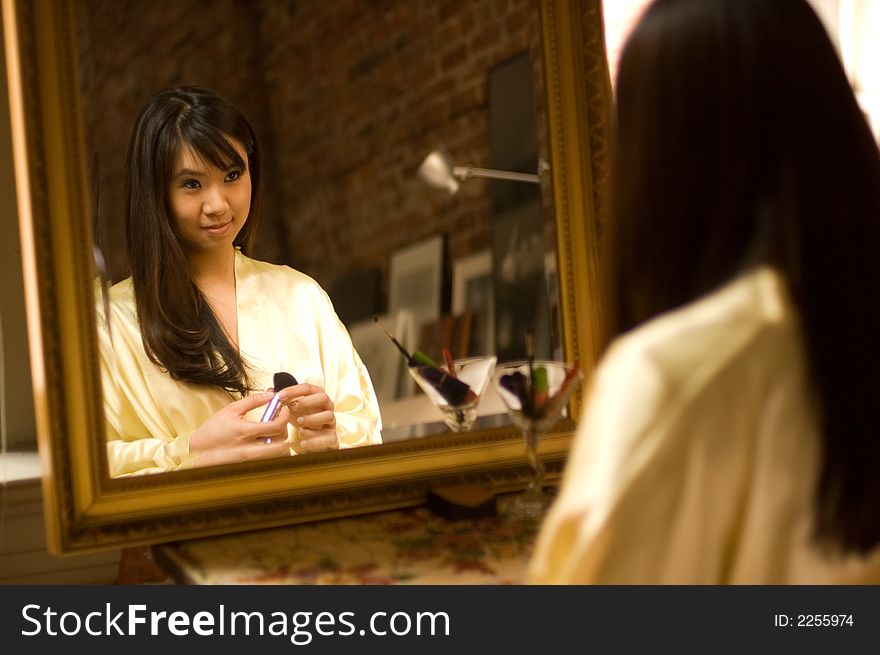 Reflection of pretty asian girl in a bathrobe smiling. Reflection of pretty asian girl in a bathrobe smiling