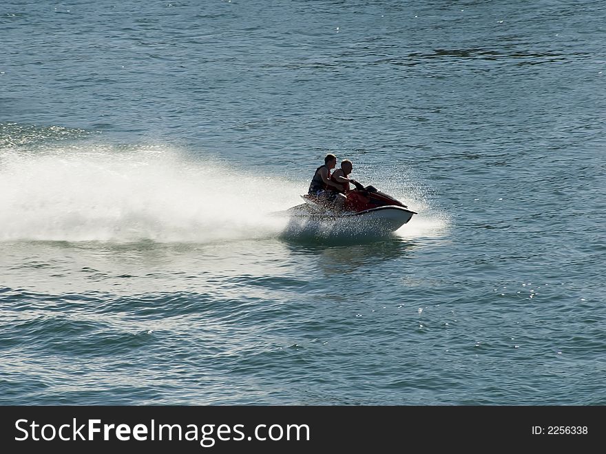 Jet skiers and wake in blue water. Jet skiers and wake in blue water