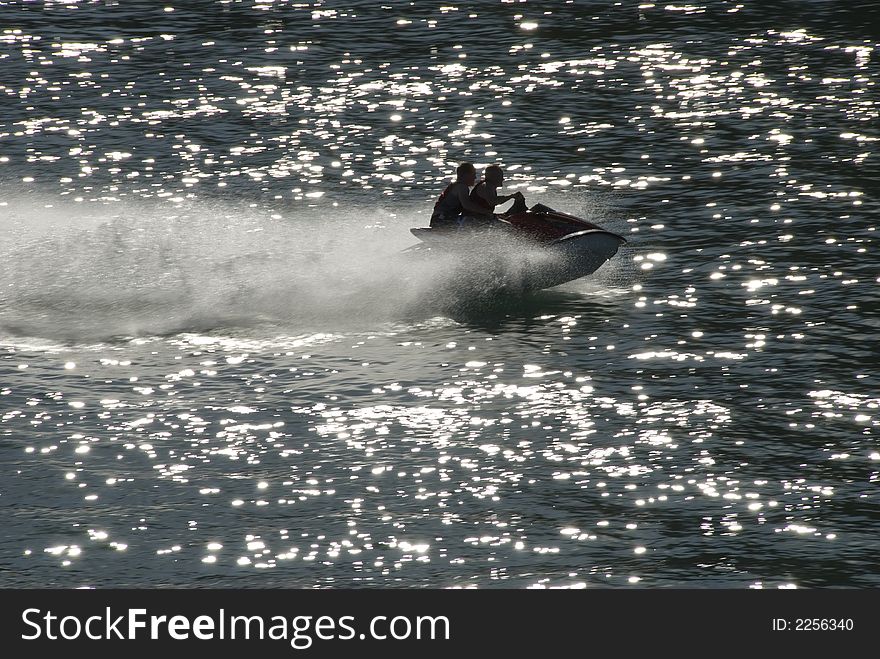 Jet ski with two people with wake and specular highlights. Jet ski with two people with wake and specular highlights