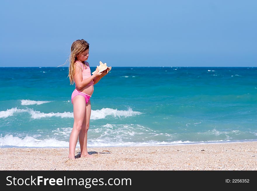 Young girl finds shell on beach. Atlantic Ocean, Florida east coast. Young girl finds shell on beach. Atlantic Ocean, Florida east coast