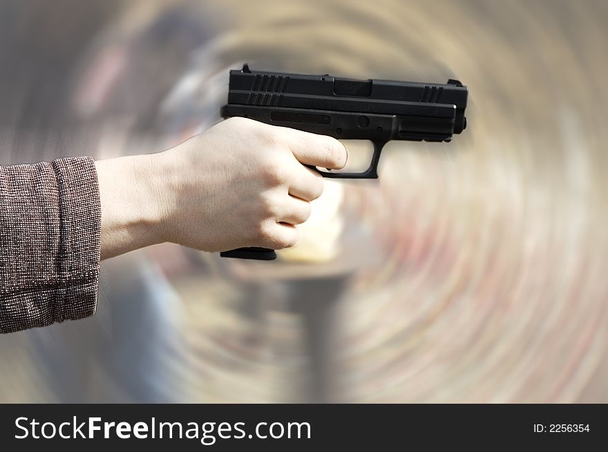 Hand holding pistol, radial background blur. Hand holding pistol, radial background blur