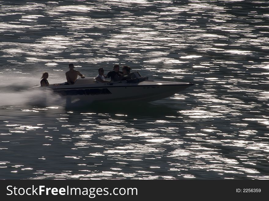 Boat showing motion in water with people and light streaks. Boat showing motion in water with people and light streaks