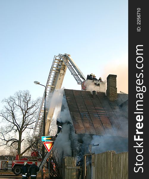 Firemen at work, Old wooden house in fire