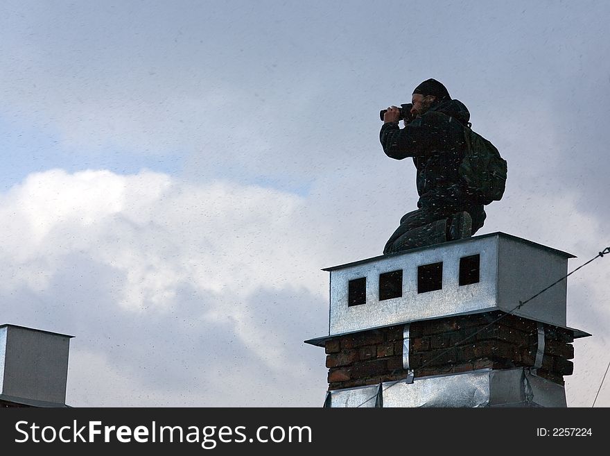 The keen photographer on a roof of the house during a bad weather