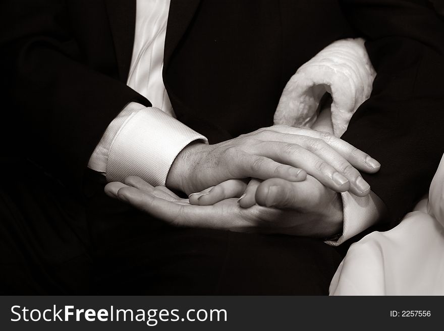Female hands in man's hands on a dark background. b/w+sepia. Female hands in man's hands on a dark background. b/w+sepia