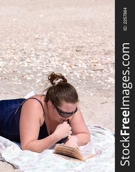 Lady relaxing on beach with book. Lady relaxing on beach with book