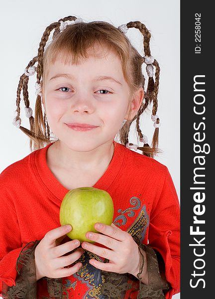 The girl in a red dress with an apple on a white background. The girl in a red dress with an apple on a white background