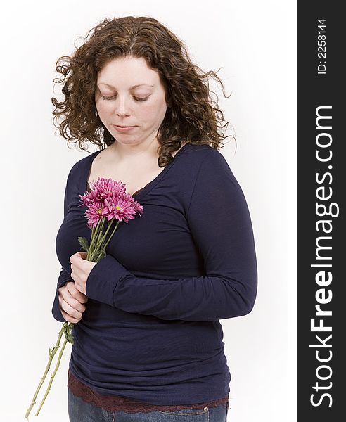 Beautiful young woman poses with red flowers