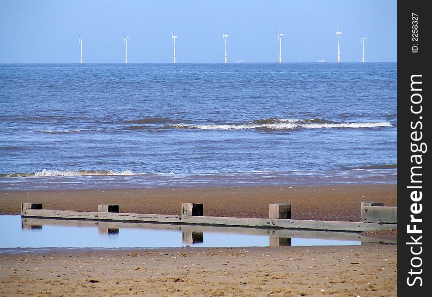Offshore wind turbines generating electric power. With beach in forground. Offshore wind turbines generating electric power. With beach in forground.
